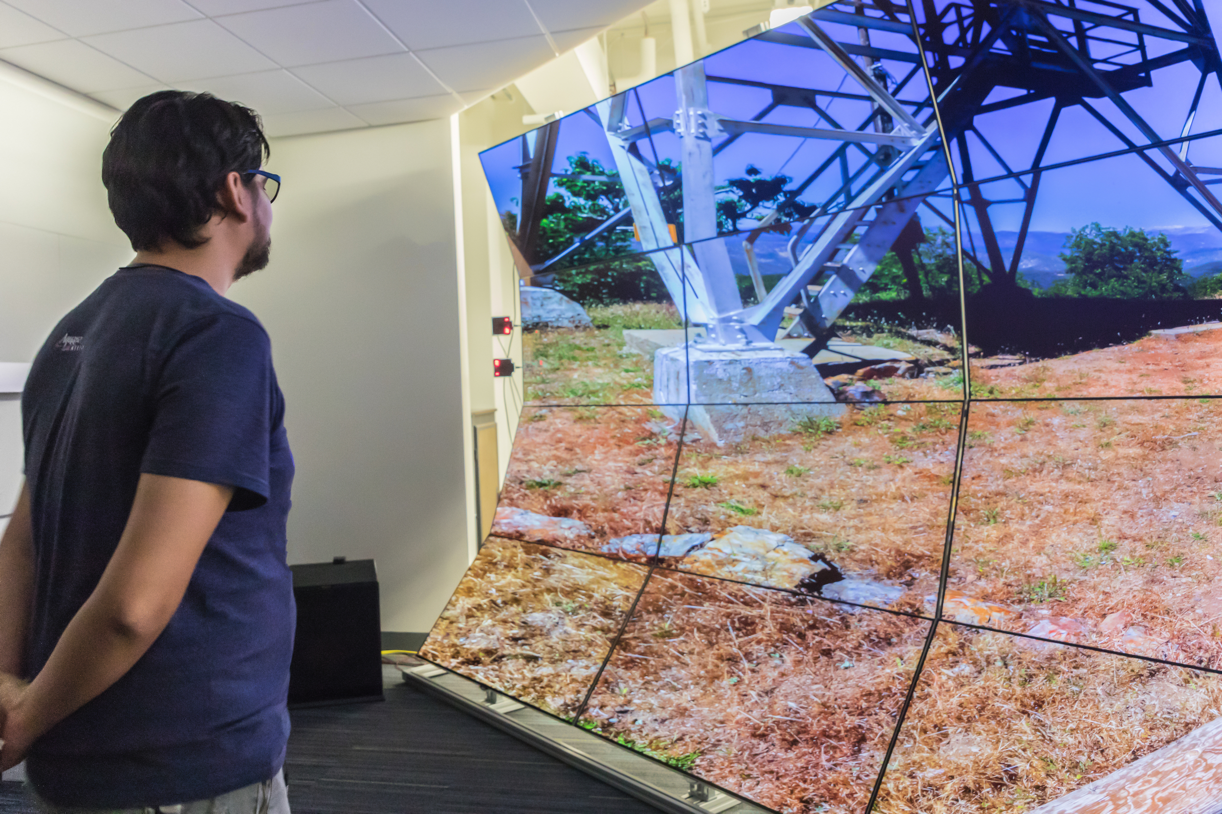 A person looking at multiple screens that has one big image, considered to be known as the WAVE Lab 