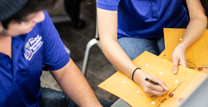 Student Accessibility Services staff working on a project folder.