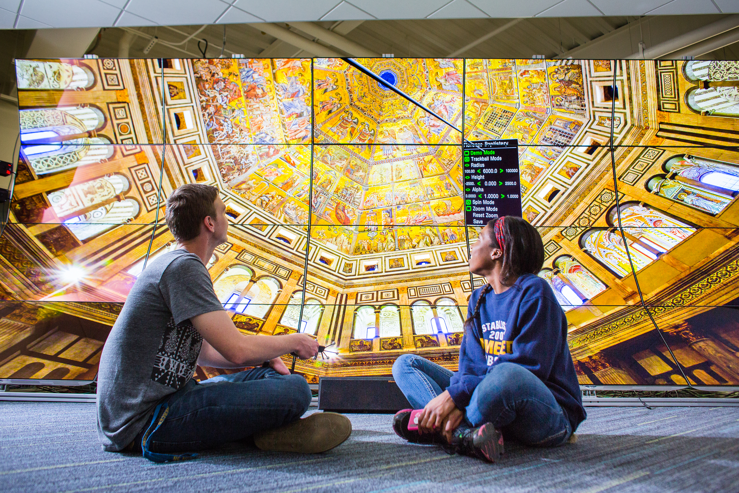 Students sitting in front of the WAVE Lab, where a large image of an ornate church ceiling is shown