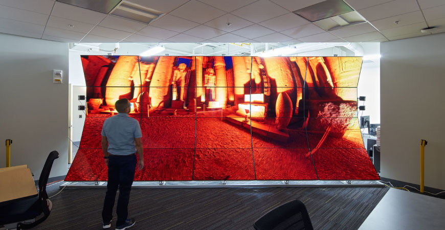 Image of a person looking at a giant projected screen in the middle with the color of red 